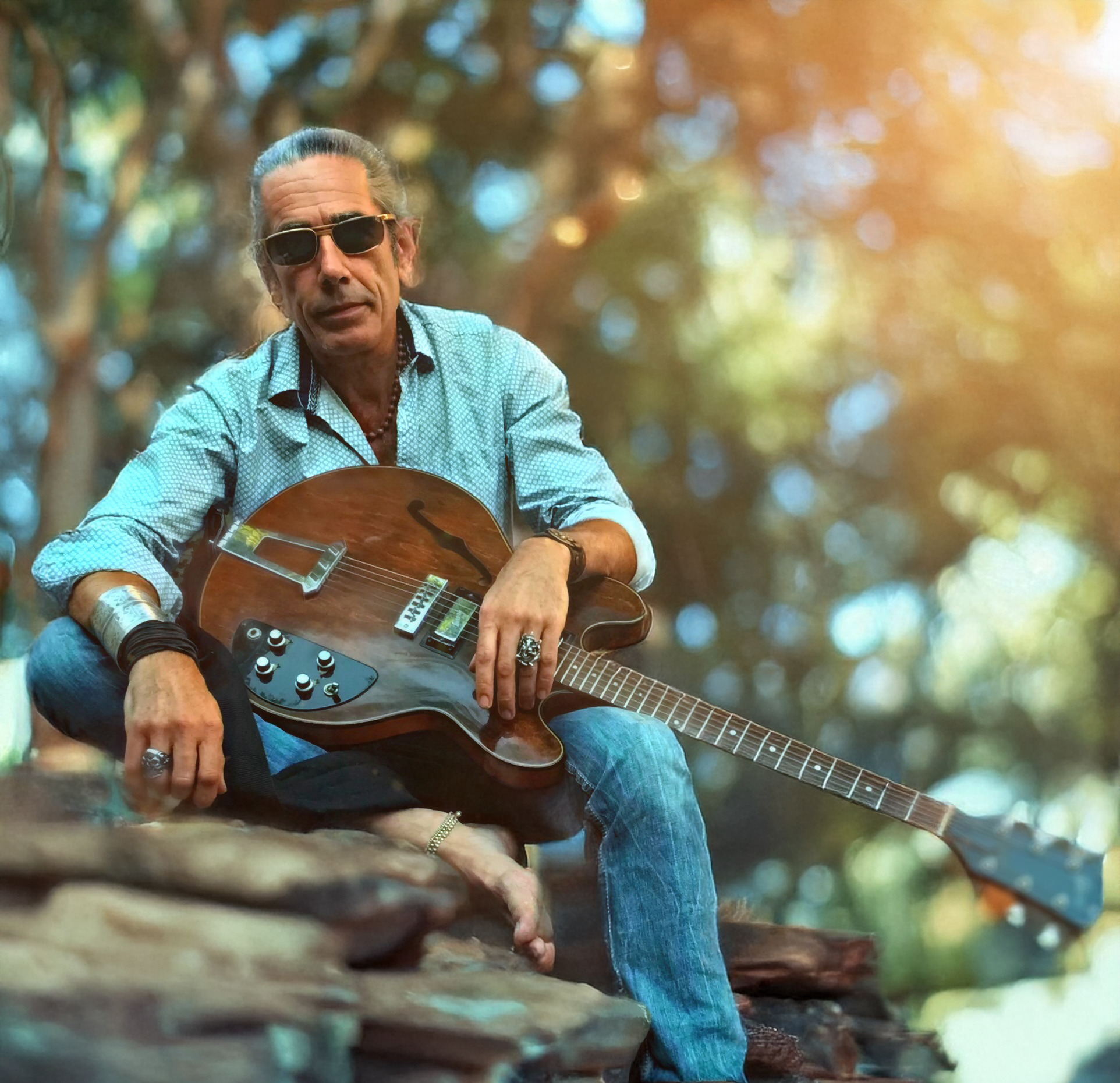 Yann Kuhlmann with guitar in the forest